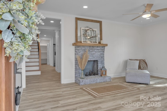 unfurnished living room with ornamental molding, a fireplace, baseboards, and wood finished floors