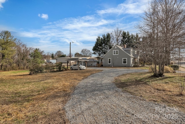 view of front of home featuring a carport and gravel driveway