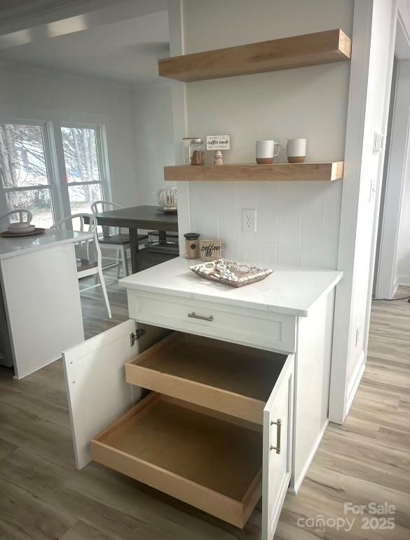 kitchen featuring light wood-style flooring, white cabinetry, open shelves, and light countertops