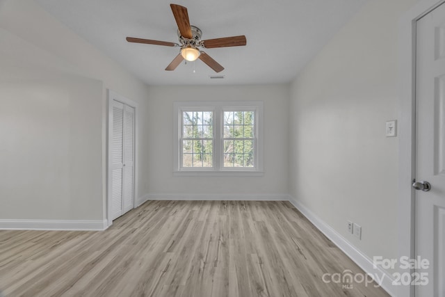 unfurnished room with light wood-type flooring, visible vents, baseboards, and a ceiling fan