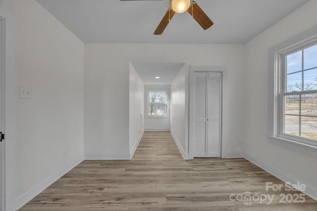 unfurnished room featuring wood finished floors, a ceiling fan, and baseboards