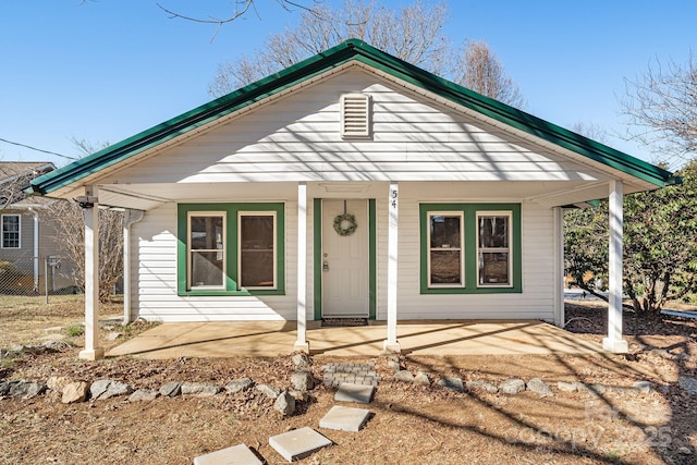 view of front of house featuring covered porch and fence