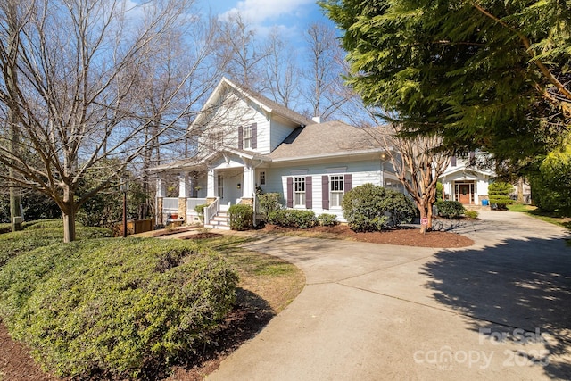 view of front of home featuring concrete driveway and roof with shingles