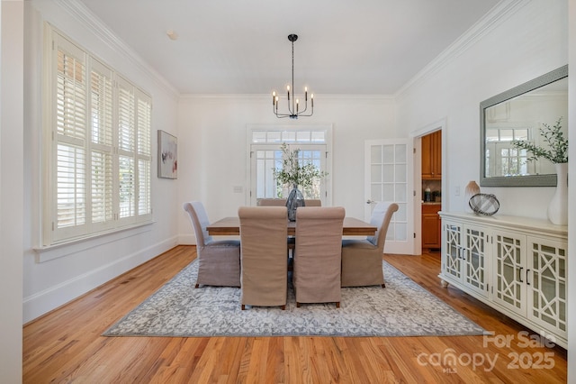 dining space featuring an inviting chandelier, wood finished floors, a wealth of natural light, and crown molding