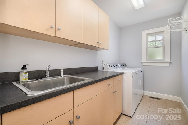 laundry room featuring light tile patterned floors, cabinet space, visible vents, independent washer and dryer, and a sink