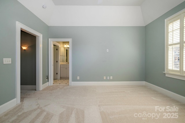 unfurnished bedroom featuring carpet floors, vaulted ceiling, and baseboards