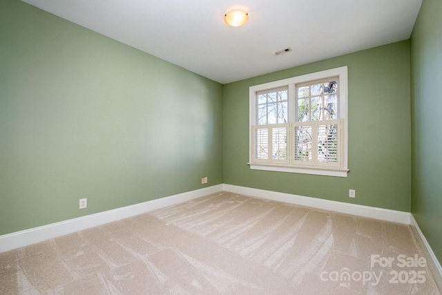 carpeted empty room with visible vents and baseboards