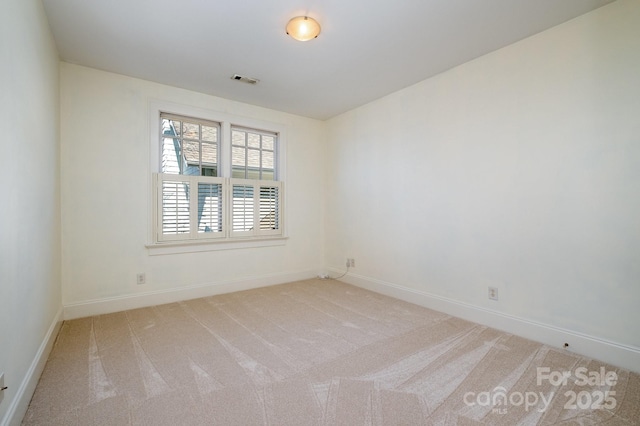 spare room featuring carpet flooring, visible vents, and baseboards