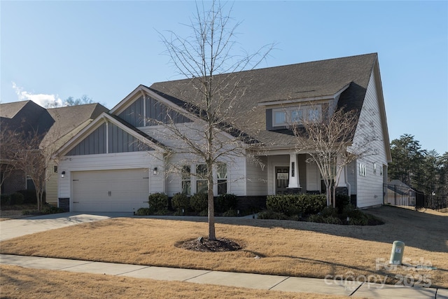 view of front of home with concrete driveway, board and batten siding, an attached garage, and a front yard