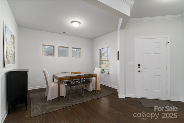 dining area with crown molding, visible vents, baseboards, and wood finished floors