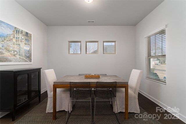 dining area with visible vents, baseboards, and wood finished floors