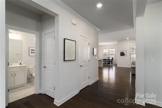 hall with dark wood-style floors, recessed lighting, baseboards, and crown molding