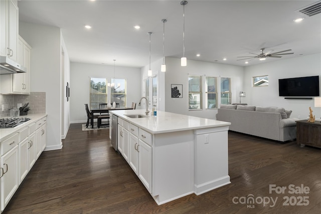 kitchen with visible vents, dark wood-style floors, a sink, stainless steel appliances, and backsplash