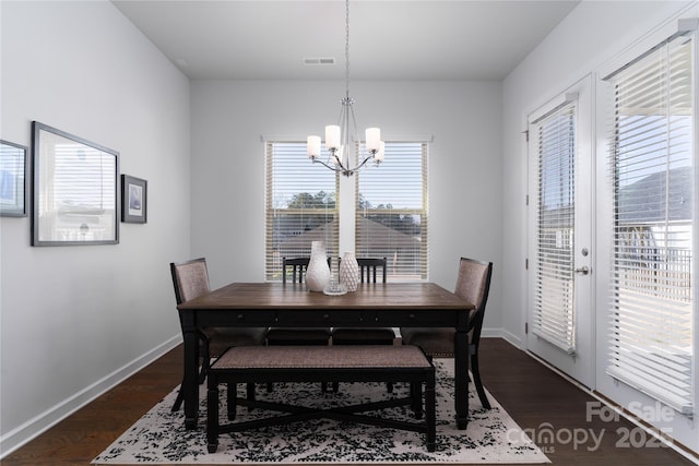 dining area with baseboards, dark wood-style flooring, visible vents, and an inviting chandelier