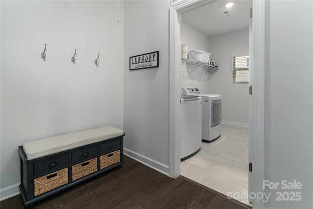 laundry room with laundry area, wood finished floors, visible vents, baseboards, and washing machine and clothes dryer