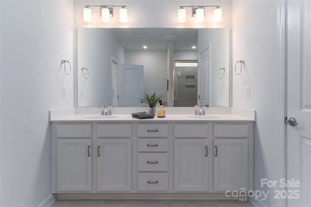 full bath featuring an enclosed shower, a sink, and double vanity