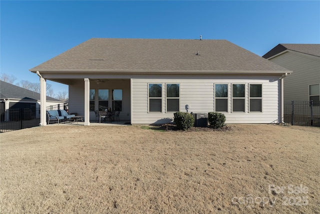 back of property featuring a shingled roof, a lawn, a patio area, fence, and ceiling fan