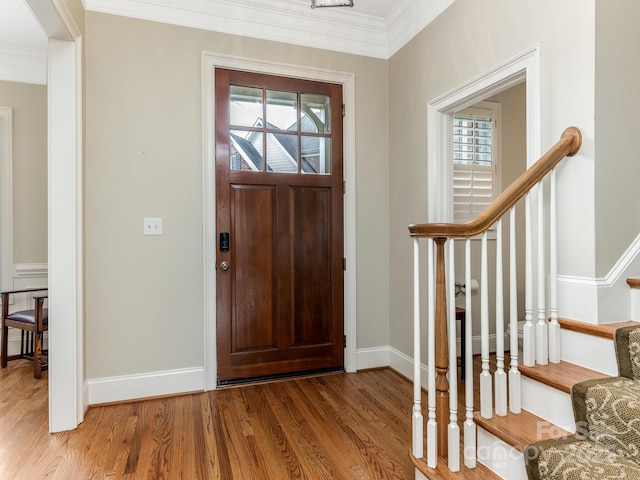 entrance foyer with crown molding, stairs, baseboards, and wood finished floors