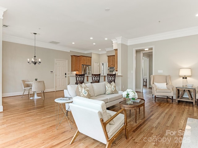 living area with light wood finished floors, baseboards, visible vents, ornamental molding, and a chandelier