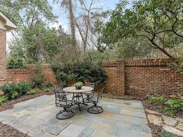 view of patio with outdoor dining area and fence