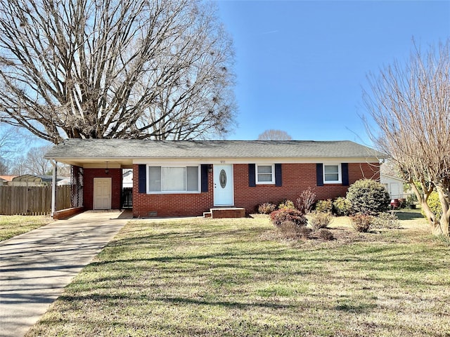 ranch-style house featuring brick siding, fence, concrete driveway, a carport, and a front yard