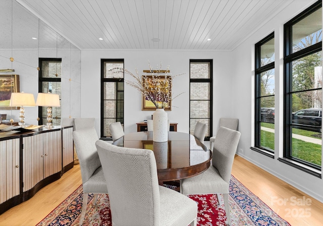 dining area with wood ceiling, a healthy amount of sunlight, crown molding, and light wood finished floors