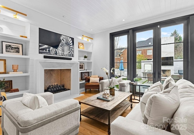 living room with built in features, a premium fireplace, recessed lighting, wood ceiling, and light wood-style floors