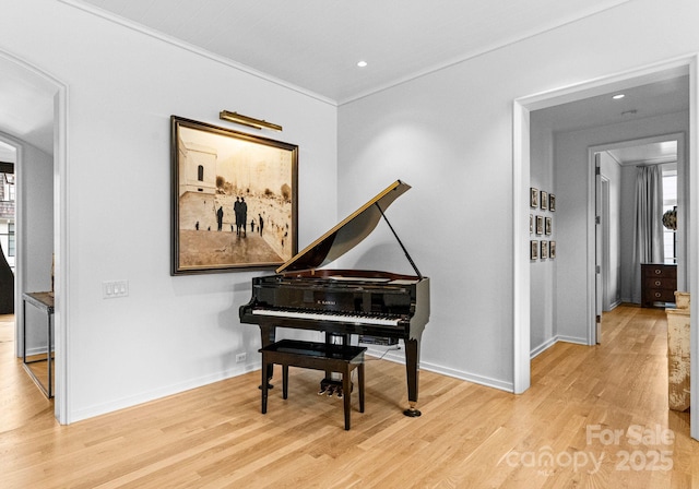 sitting room with wood finished floors, baseboards, and ornamental molding