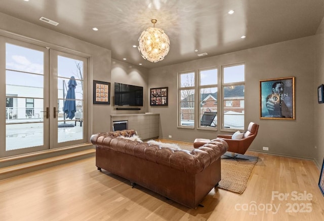 living room with wood finished floors, visible vents, baseboards, recessed lighting, and a fireplace