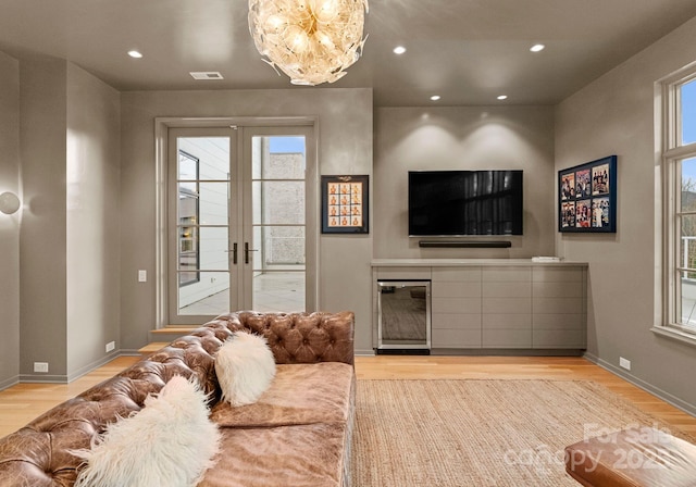 living area with recessed lighting, french doors, light wood-type flooring, and baseboards