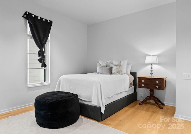 bedroom with wood finished floors and baseboards