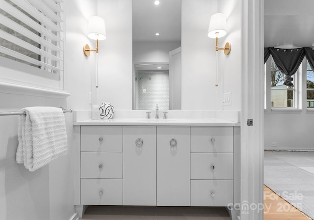 bathroom featuring vanity, recessed lighting, and baseboards