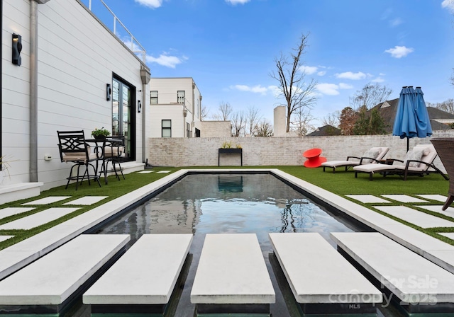 view of swimming pool featuring a fenced backyard