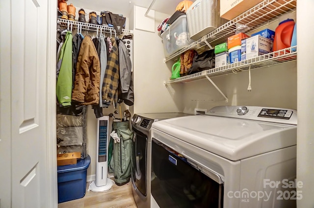 laundry area featuring wood finished floors, laundry area, and washing machine and clothes dryer