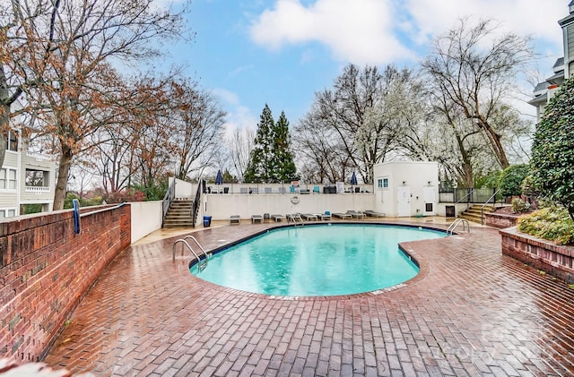 view of swimming pool featuring a patio and fence