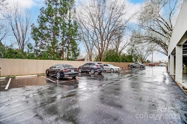 uncovered parking lot featuring fence