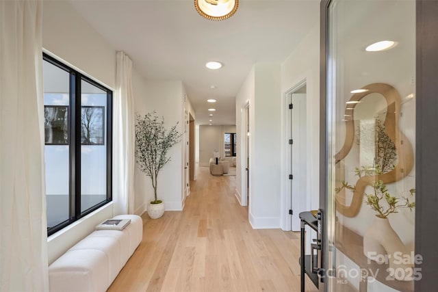 hall featuring light wood-style floors, baseboards, and recessed lighting