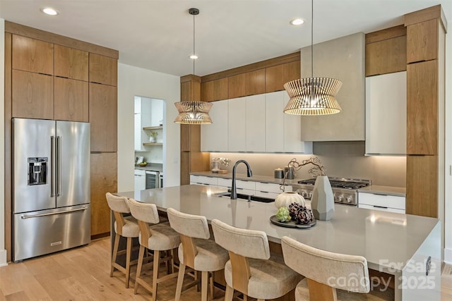 kitchen featuring a sink, modern cabinets, range, and high end fridge