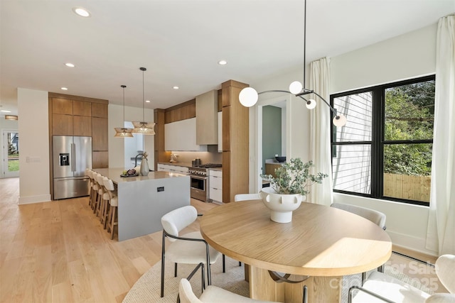 dining area with light wood-style flooring, baseboards, and recessed lighting