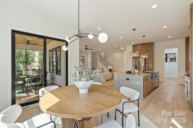 dining room with stairs, a ceiling fan, light wood-style flooring, and recessed lighting