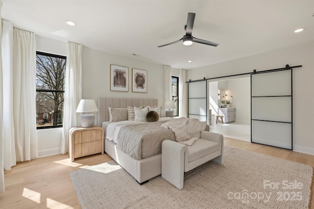 bedroom featuring ceiling fan, a barn door, recessed lighting, baseboards, and light wood-type flooring