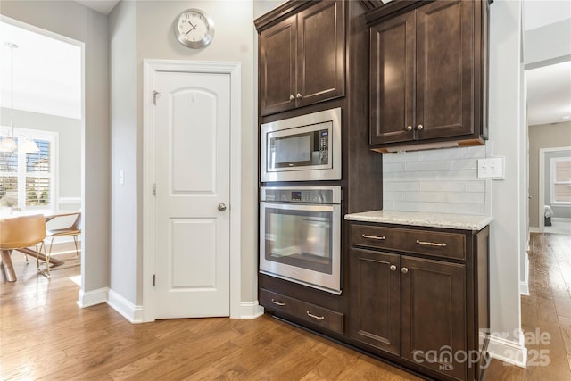 2934 Hiddenbrook Way, Fort Mill, SC 29707 - kitchen featuring baseboards, stainless steel appliances, dark brown cabinets, light wood-type flooring, and backsplash