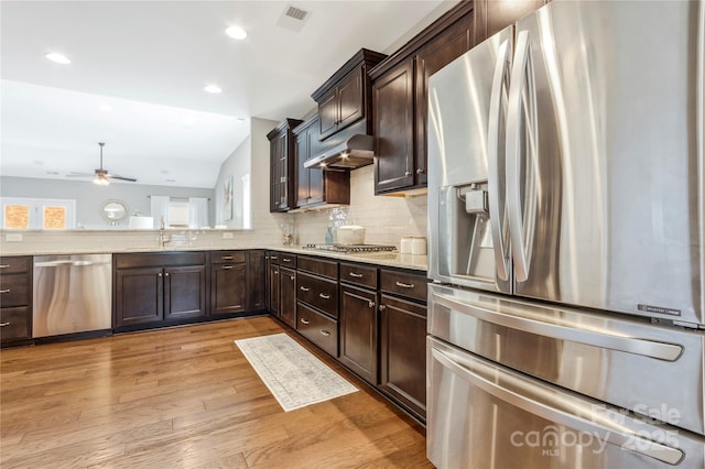 2934 Hiddenbrook Way, Fort Mill, SC 29707 - kitchen with visible vents, light wood-type flooring, under cabinet range hood, backsplash, and appliances with stainless steel finishes
