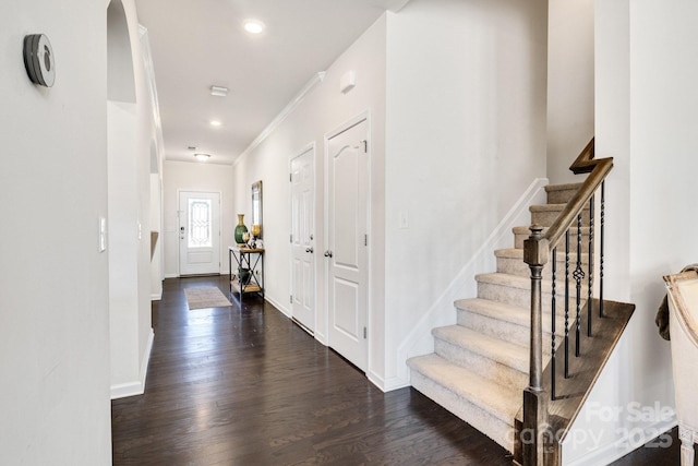 foyer entrance featuring stairway, baseboards, wood finished floors, and recessed lighting