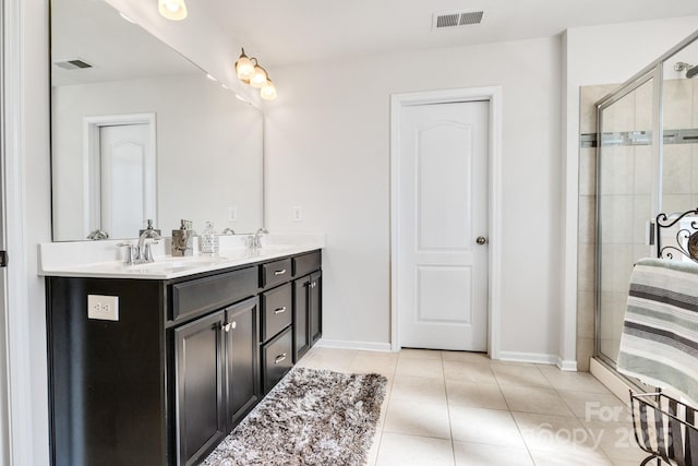 bathroom featuring tile patterned flooring, visible vents, a sink, and a shower stall