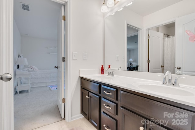 bathroom with double vanity, a sink, and ensuite bathroom