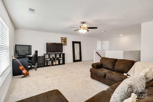 living room with a ceiling fan, carpet, visible vents, and baseboards