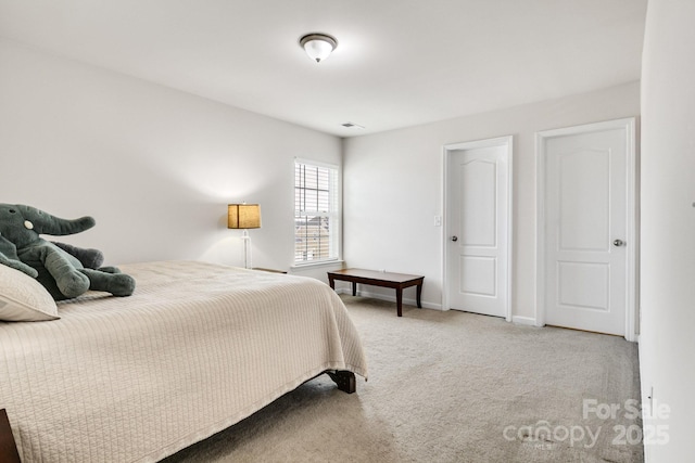 bedroom featuring carpet floors, visible vents, and baseboards