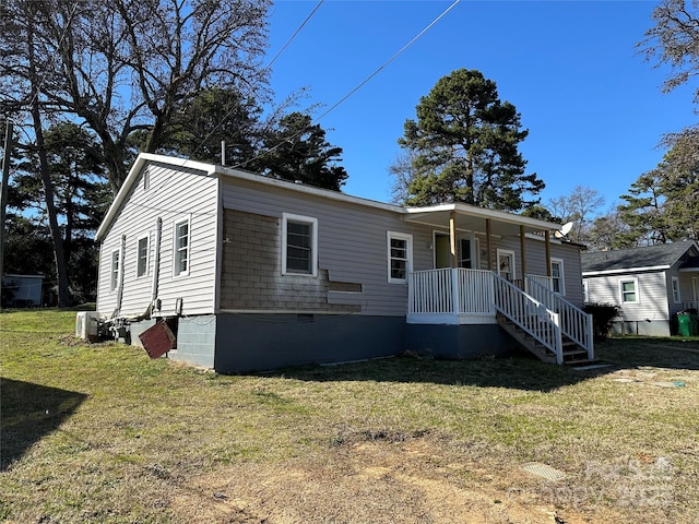 view of front of property featuring a porch, a front yard, and crawl space