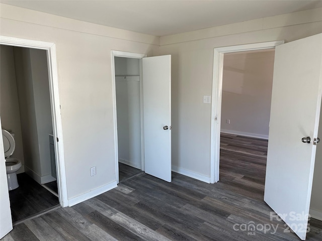 unfurnished bedroom with dark wood-style flooring, a closet, and baseboards